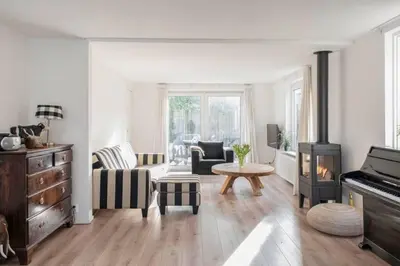 a living room with a fireplace and a piano at klaproos Bergen NH in Bergen