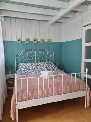 a bedroom with a bed with a blue wall at Bed en breakfast Onder aan de dijk in Warder