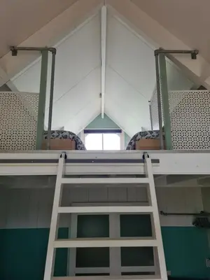 a ladder in a room with chairs at Bed en breakfast Onder aan de dijk in Warder