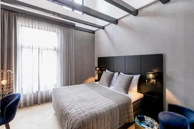 a bedroom with a bed and a large window at Cavallaro Hotel in Haarlem