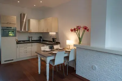 a kitchen with a table and chairs and a kitchen with white cabinets at Smederij Schoorldam in Schoorl