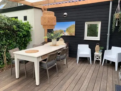 a patio with a white table and chairs at Smederij Schoorldam in Schoorl