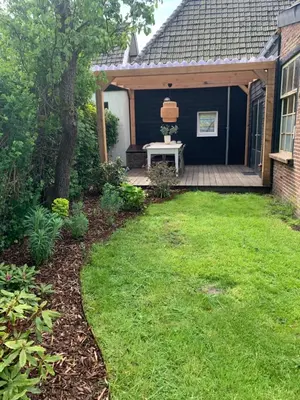 a backyard with a table on a wooden deck at Smederij Schoorldam in Schoorl