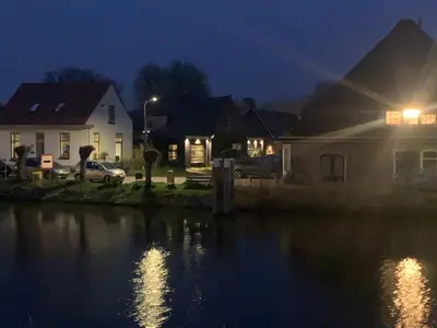 a group of houses next to a river at night at Smederij Schoorldam in Schoorl