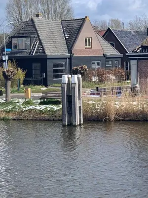 a house on the shore of a body of water at Smederij Schoorldam in Schoorl