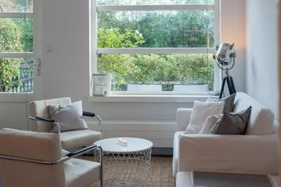 a living room with two chairs and a window at Smederij Schoorldam in Schoorl