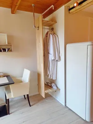a room with a desk and a refrigerator and a table at Suite Pura Vida in Oud-Ade