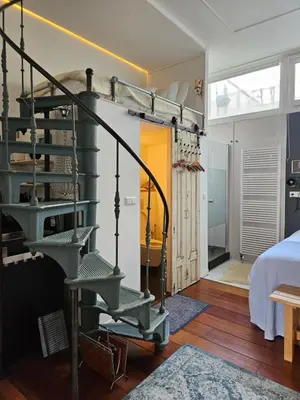 a room with a spiral staircase and a bedroom at Waterfront Studio in Amsterdam