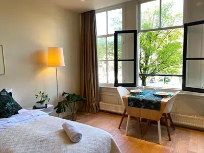 a bedroom with a bed and a table and a window at The Canalview Retreat in Amsterdam