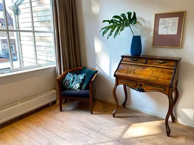 a desk and a chair in a room with a plant at The Canalview Retreat in Amsterdam
