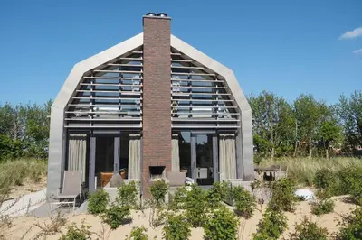 a building in the middle of the sand with a brick at Zicht op de Molen by Droomvilla in Egmond aan den Hoef
