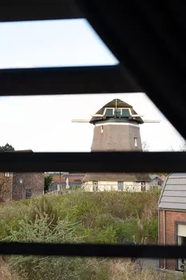 a view from a window of a building with a tower at Zicht op de Molen by Droomvilla in Egmond aan den Hoef