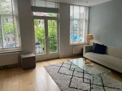 a living room with a couch and a glass table at Great Apartment Amsterdam in Amsterdam