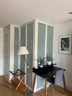 a room with a desk and a lamp and some windows at Great Apartment Amsterdam in Amsterdam
