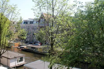 a view of a river with buildings and a boat at Great Apartment Amsterdam in Amsterdam