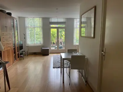a living room with a table and a dining room at Great Apartment Amsterdam in Amsterdam