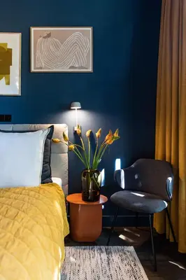 a bedroom with a blue wall with a bed and a chair at Luxurious Residence in Vondelpark/Museum District in Amsterdam