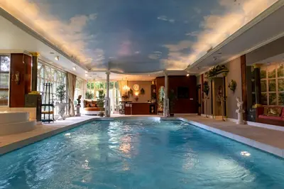 a swimming pool in a room with a ceiling at Amsterdamgarden - stunning garden villa with pool close to Amsterdam in Laren