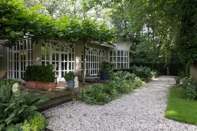 a garden with a gazebo with plants and trees at Amsterdamgarden - stunning garden villa with pool close to Amsterdam in Laren