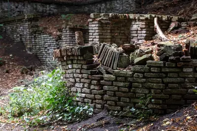a crumbling brick wall with a bench in it at Amsterdamgarden - stunning garden villa with pool close to Amsterdam in Laren