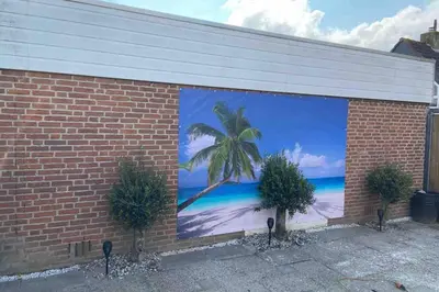 a mural of a palm tree on the side of a building at Casa The Wave with infrared sauna in Noordwijkerhout