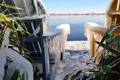 an ice covered chair sitting next to a body of water at Casa The Wave with infrared sauna in Noordwijkerhout