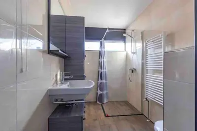 a bathroom with a sink and a shower at Casa The Wave with infrared sauna in Noordwijkerhout