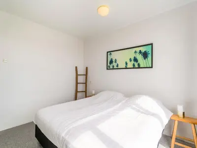 a bedroom with a bed and a picture on the wall at Apartment near North Sea and Lighthouse in Egmond aan Zee