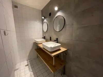 a bathroom with two sinks and two mirrors at Apartment near North Sea and Lighthouse in Egmond aan Zee
