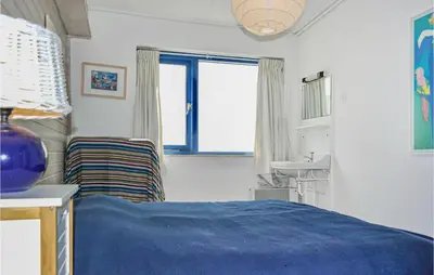 a bedroom with a blue bed and a sink at Bergenhuisje in Bergen aan Zee