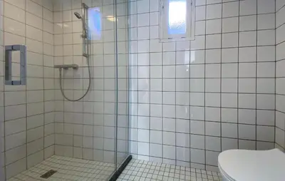 a bathroom with a shower and a toilet at Bergenhuisje in Bergen aan Zee