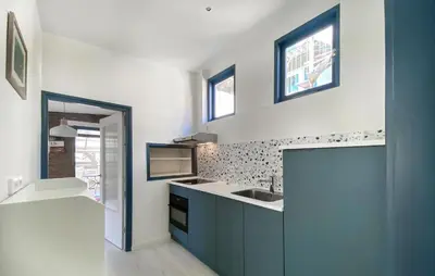 a kitchen with blue cabinets and a sink at Bergenhuisje in Bergen aan Zee