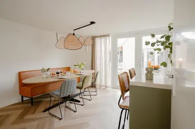a kitchen and dining room with a table and chairs at Dromen in de duinen by Droomvilla in Sint Maarten