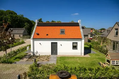 an orange roofed house with an orange roof at Dromen in de duinen by Droomvilla in Sint Maarten