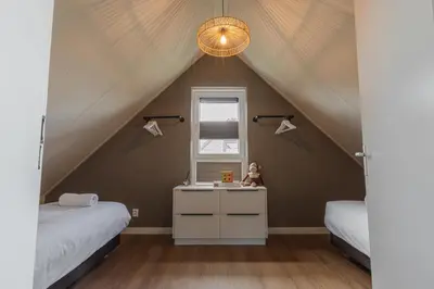 a room with two beds and a sink in a attic at Relaxen aan de kust by Droomvilla in Sint Maarten
