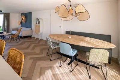 a living room with a wooden table and chairs at Slapen tussen de duinen by Droomvilla in Sint Maarten