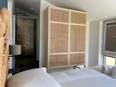 a bedroom with a bed and a large window at Slapen tussen de duinen by Droomvilla in Sint Maarten