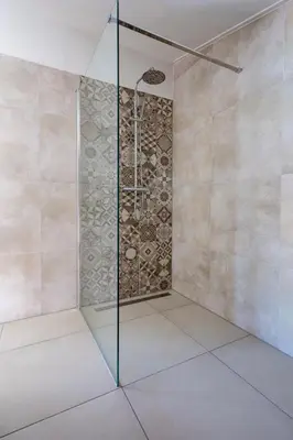a shower with a glass door in a bathroom at Slapen tussen de duinen by Droomvilla in Sint Maarten