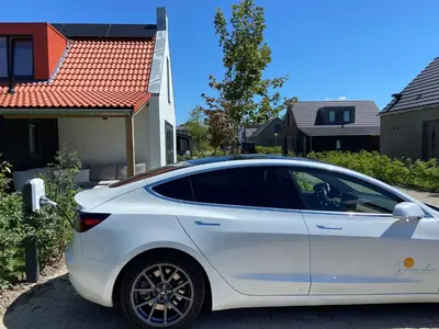 a white car parked in front of a house at Slapen tussen de duinen by Droomvilla in Sint Maarten