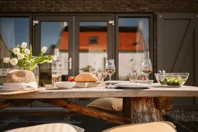 a table with glasses of wine and food on it at Buiten aan zee by Droomvilla in Sint Maarten