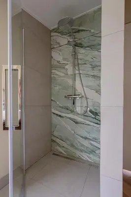 a shower in a bathroom with a stone wall at Modern Sint Maarten by Droomvilla in Sint Maarten