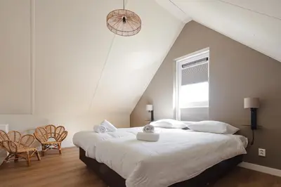 a white bedroom with two beds and a window at Modern Sint Maarten by Droomvilla in Sint Maarten