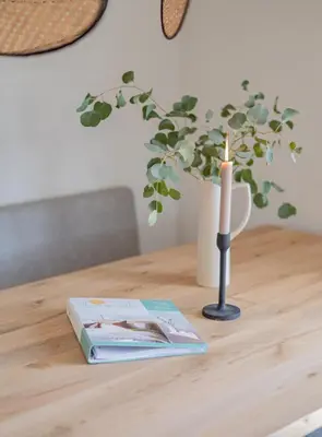 a candle and a book on a table with a book at Slapen aan zee by Droomvilla in Sint Maarten