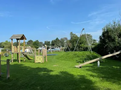 a park with a bunch of playground equipment in the grass at Slapen aan zee by Droomvilla in Sint Maarten