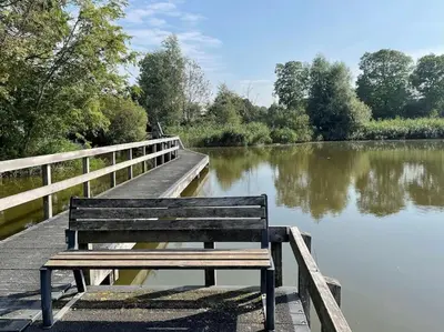 a wooden bench sitting on a dock next to a lake at Slapen aan zee by Droomvilla in Sint Maarten