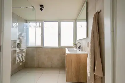 a bathroom with a sink and a shower with windows at Hip in Sint Maarten by Droomvilla in Sint Maarten