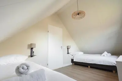a attic bedroom with two beds and a mirror at Hip in Sint Maarten by Droomvilla in Sint Maarten