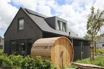 a house with a wooden barrel in front of it at Ultiem genieten in Sint Maarten by Droomvilla in Sint Maarten