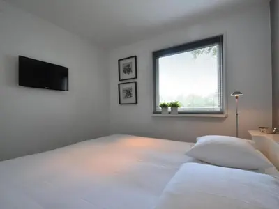 a white bedroom with a bed and a window at Riverside holiday home near Amsterdam in Nigtevecht
