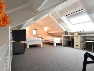 a room with two beds and a desk and a tv at Riverside holiday home near Amsterdam in Nigtevecht